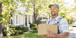 Postal worker delivering packages on a sunny Saturday morning.